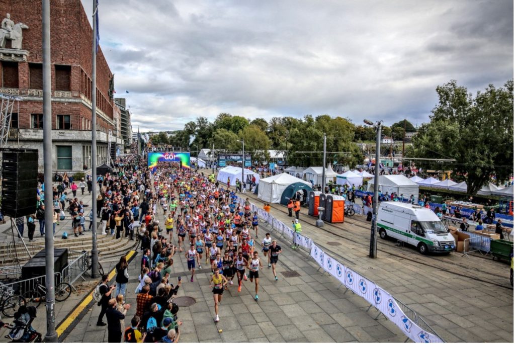 Mehrere Marathon-Läufer beim Oslo Marathon, die von der Menge angejubelt werden.